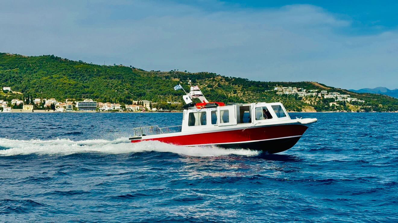 Poseidon vessel cruising the Saronic Gulf with Spetses in the background